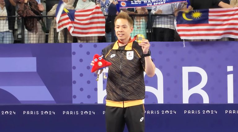 Cheah Liek Hou shows off his gold medal after the prize giving ceremony.