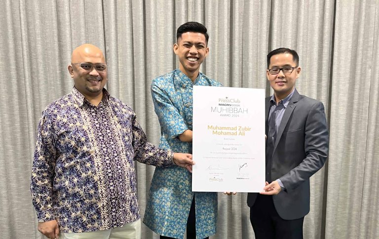 Zubir Khan receives his Muhibbah award from National Press Club Malaysia exco member Abdul Rahmat Omar Mohammed Hanif and Macrokiosk CEO Datuk Kenny Goh in Kuala Lumpur on Oct 22, 2024.