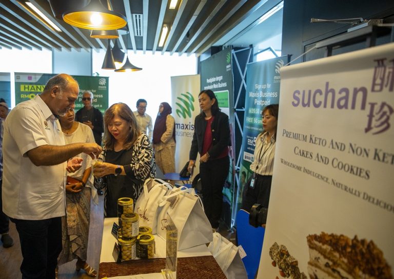 Digital Minister Gobind Singh Deo trying a cookie at a kiosk during the EmpowerHER Digital Programme at Menara Maxis in Kuala Lumpur on April 18,2025.