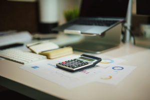 A calculator next to a laptop.