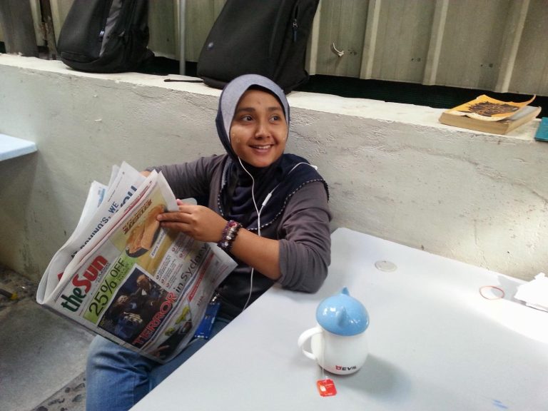 Hafsar Tameesuddin reading a local newspaper in Kuala Lumpur.