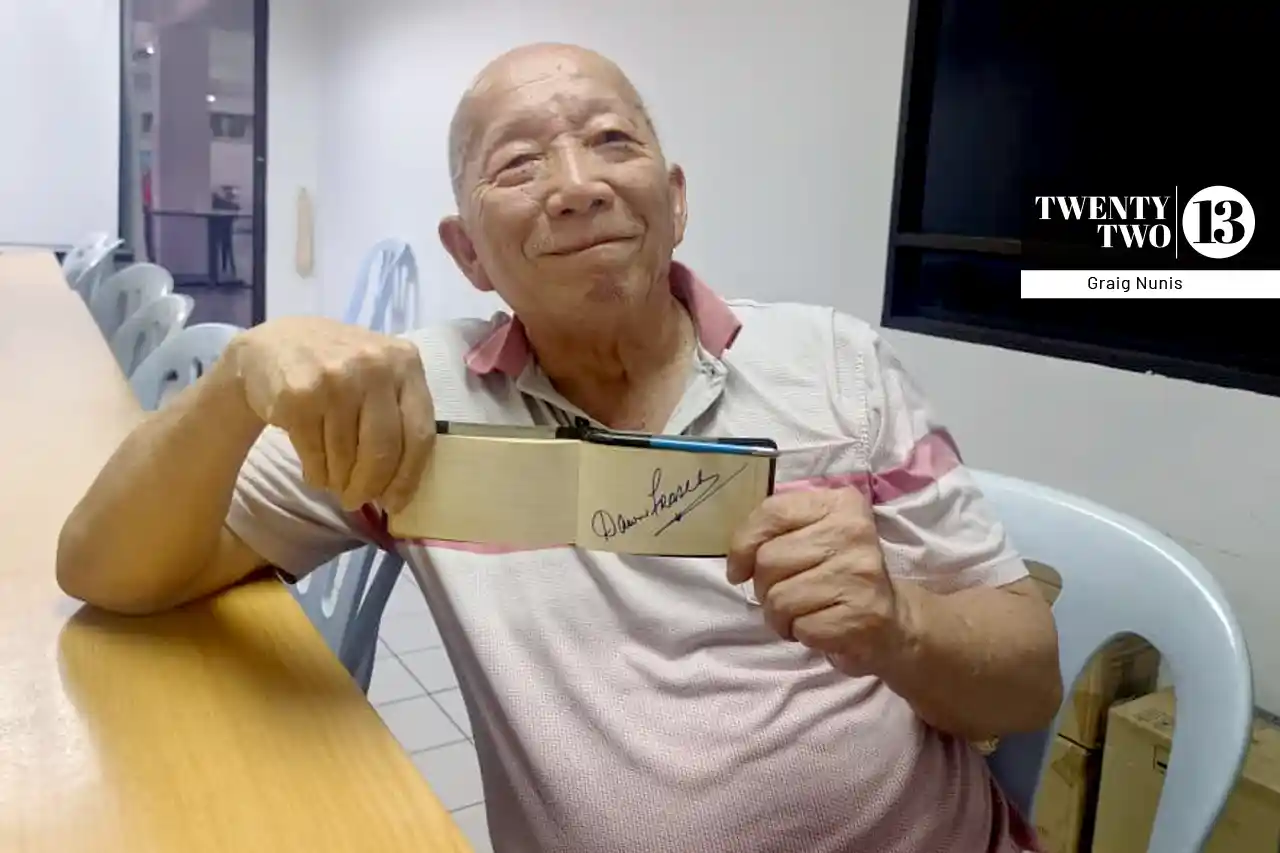 Olympian Cheah Tong Kim posing with his diary with autographs.