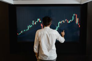 Man staring at a graph on a big screen.