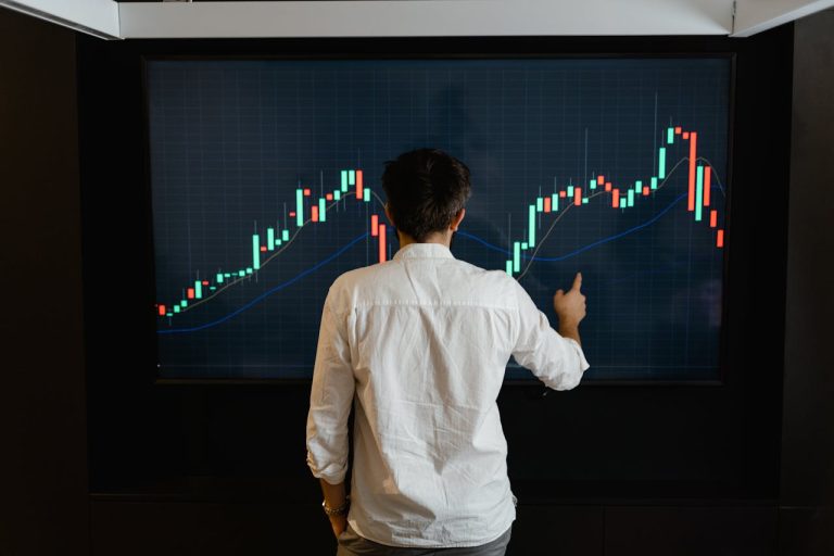 Man staring at a graph on a big screen.