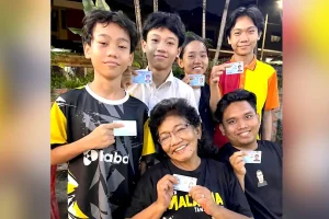 Shiela Rahman (seated) with the five children proudly showing their MyKads.