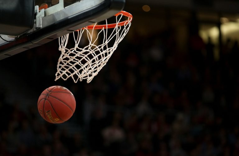 A basketball exiting the hoop