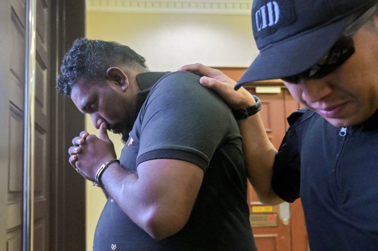 R.Krishnan being escorted by a policeman at the Kuala Lumpur Court Complex in Jalan Duta on Nov 28, 2025.