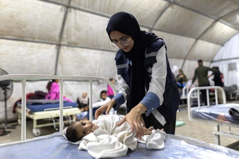 A female doctor checks on a baby in a makeshift hospital in the Gaza Strip.