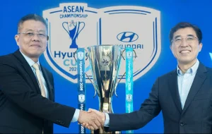 Representatives from AFF and Hyundai shake hands as they unveil the trophy for the 2026 Asean Championship Hyundai Cup.