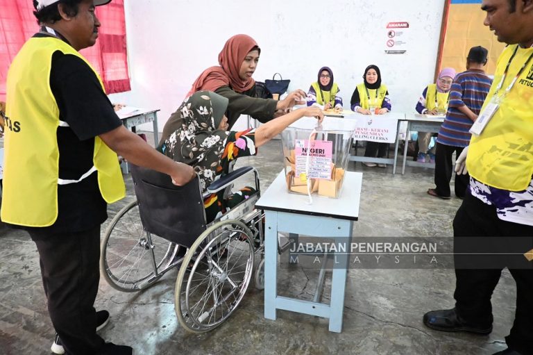 A voter on a wheelchair casting her vote during the Sabah elections on Nov 29, 2025.