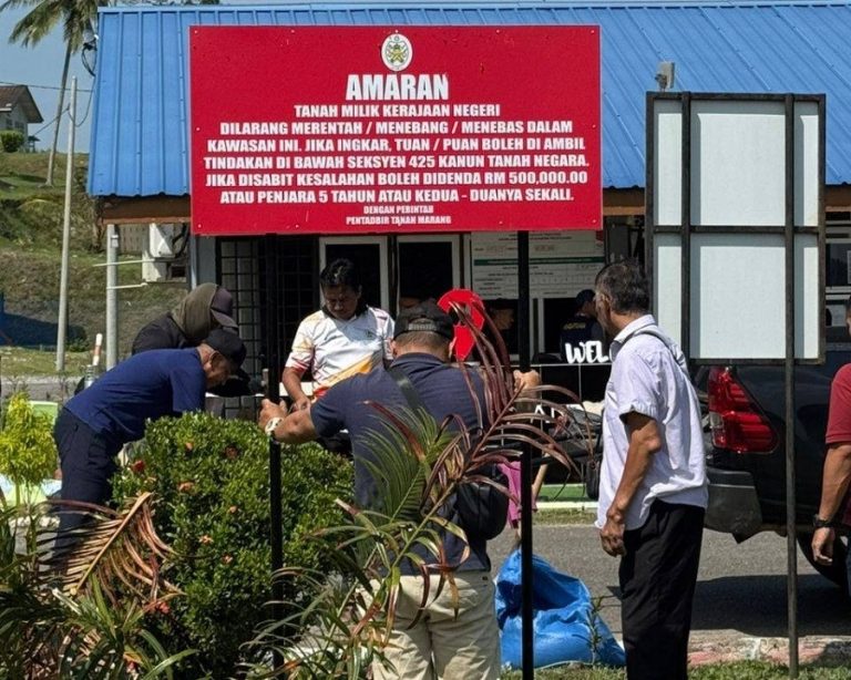 Terengganu state government officials put up a sign to inform the public not to encroach into its land.