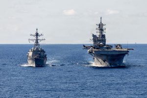 Arleigh Burke-class guided-missile destroyer USS Rafael Peralta (DDG 115) receives fuel from America-class amphibious assault ship USS Tripoli (LHA 7) during a replenishment-at-sea in the Philippine Sea. Rafael Peralta is forward-deployed and assigned to Destroyer Squadron (DESRON) 15, the Navy's largest DESRON and the U.S. 7th Fleet's principal surface force.