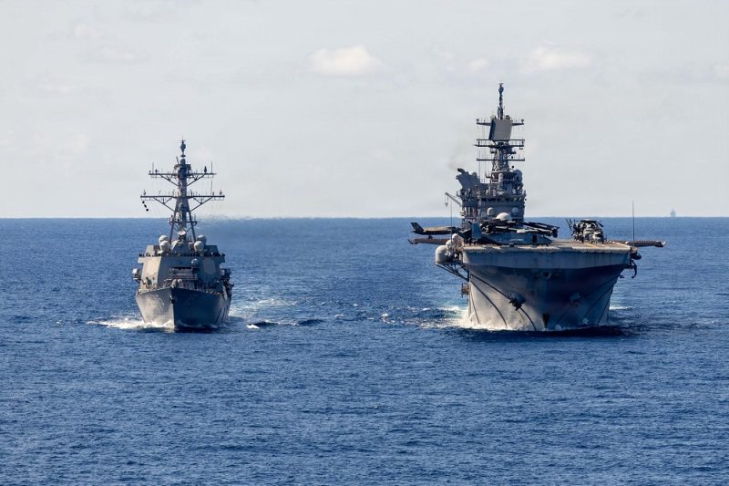 Arleigh Burke-class guided-missile destroyer USS Rafael Peralta (DDG 115) receives fuel from America-class amphibious assault ship USS Tripoli (LHA 7) during a replenishment-at-sea in the Philippine Sea. Rafael Peralta is forward-deployed and assigned to Destroyer Squadron (DESRON) 15, the Navy's largest DESRON and the U.S. 7th Fleet's principal surface force.