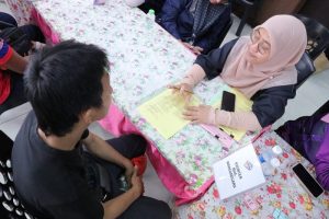A visitor speaking to a National Registration Department personnel regarding the application of Malaysian citizenship.
