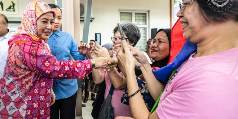 Raja Zarith Sofia greeting residents at a low-cost housing scheme in Kuala Lumpur.