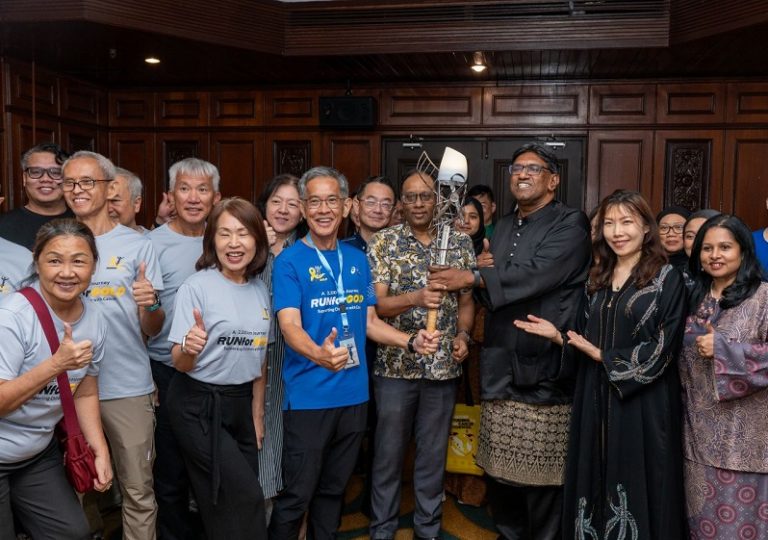 Lim Shyang Guey in a blue shirt is joined by members of the National Cancer Society Malaysia.