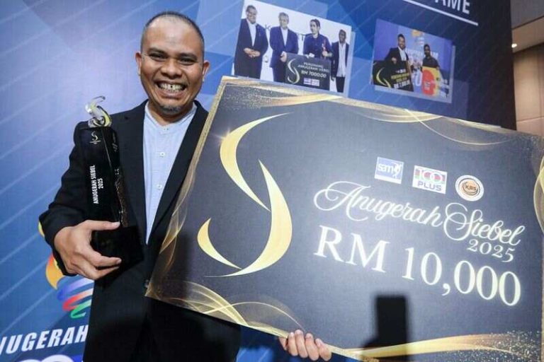Muhammad Rizal Hashim posing with a cheque at the SAM-100Plus 2025 Awards on May 13, 2026.