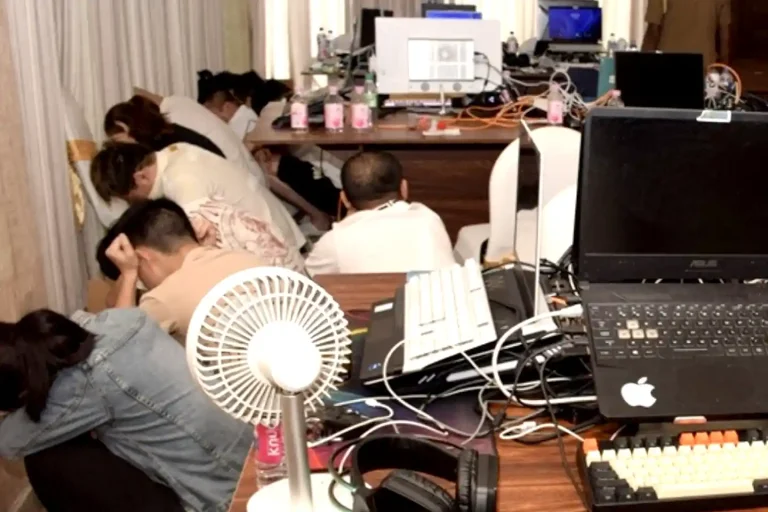 Alleged scammers squatting on the floor during an Interpol Operation First Light 2026 bust.