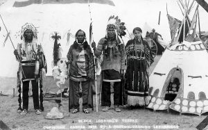 Black and white photograph Black Looking's Family next to their teepee.