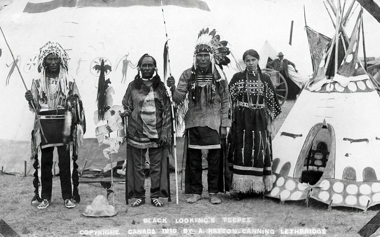 Black and white photograph Black Looking's Family next to their teepee.